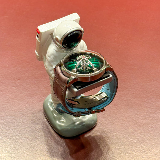 Spaceman watch holder displaying a wristwatch against a red background – Artisan Watch Co.