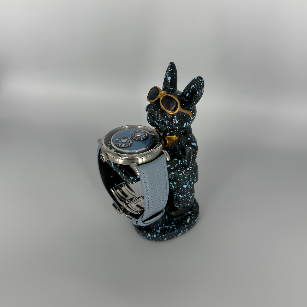 Galaxy Dog figurine watch holder with blue splatter finish and gold aviators, displaying a watch on its arm – Artisan Watch Co.